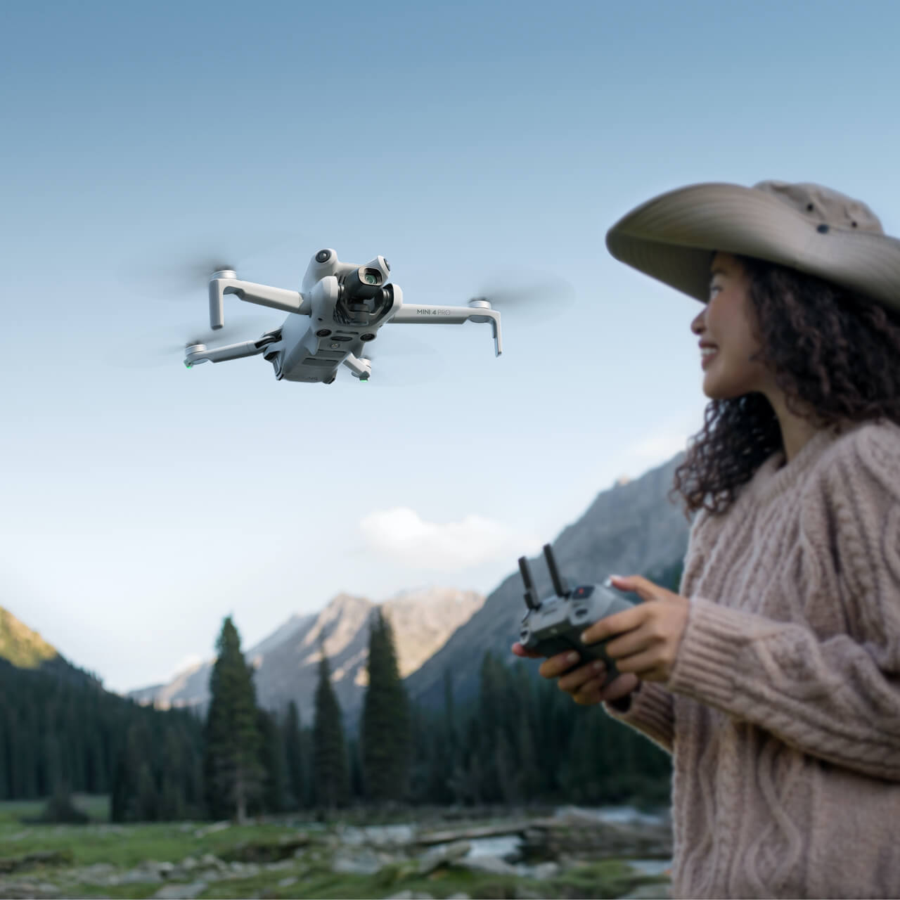 DJI MINI 4 PRO SCENARIO Person flying a drone in a mountainous landscape