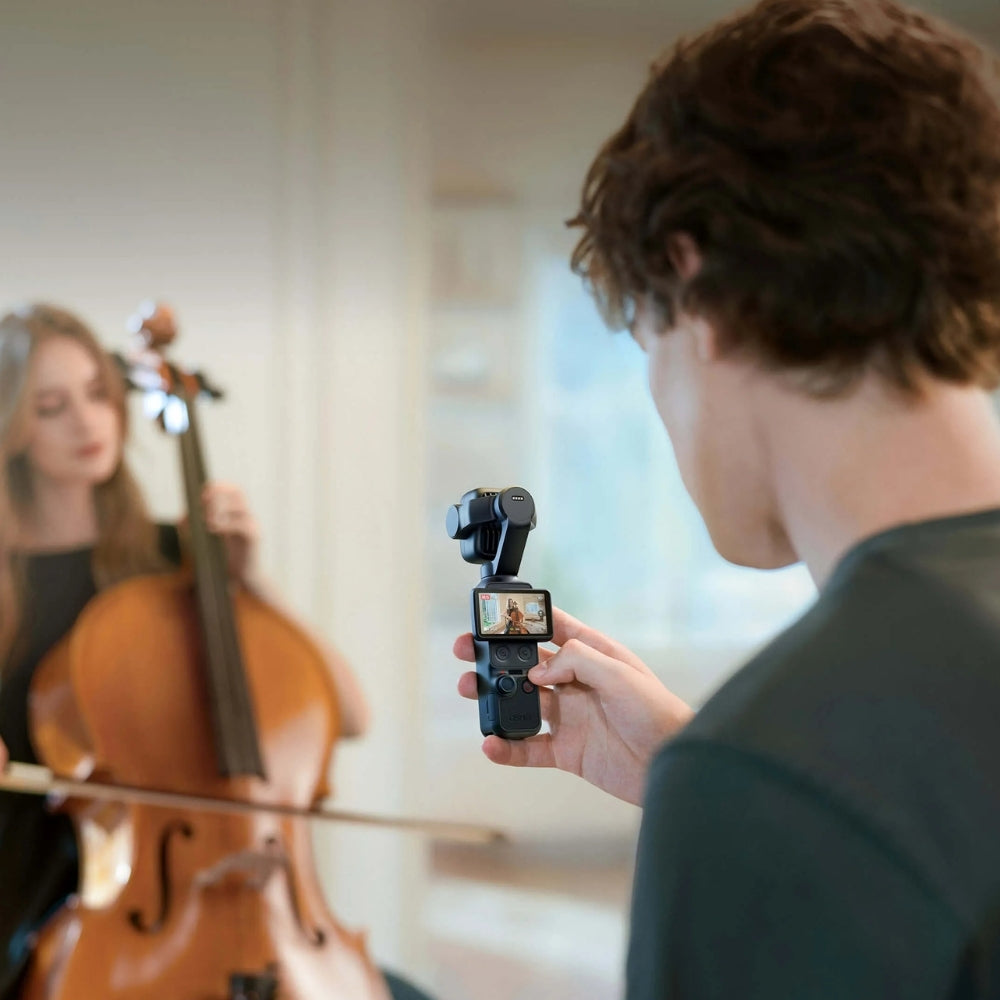 DJI Osmo Pocket 4P Dual-Camera Pocket Gimbal, 1-Inch Sensor, 60mm 3x Zoom, bkack, Person recording a video of another person playing a cello with a smartphone on a gimbal.